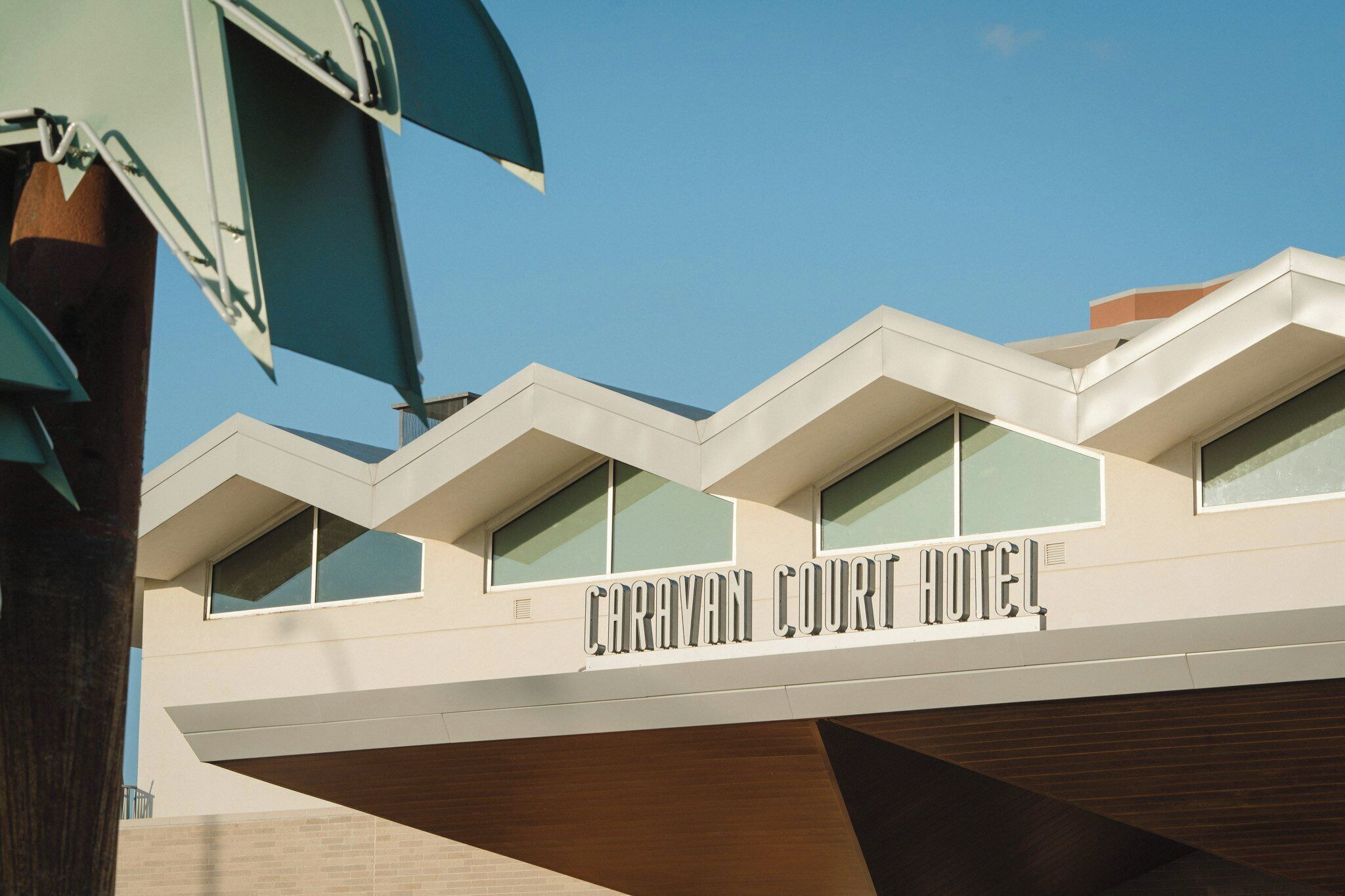 Ein modernes Gebäude mit der Aufschrift 'Caravan Court Hotel', das ein Hotel kennzeichnet.