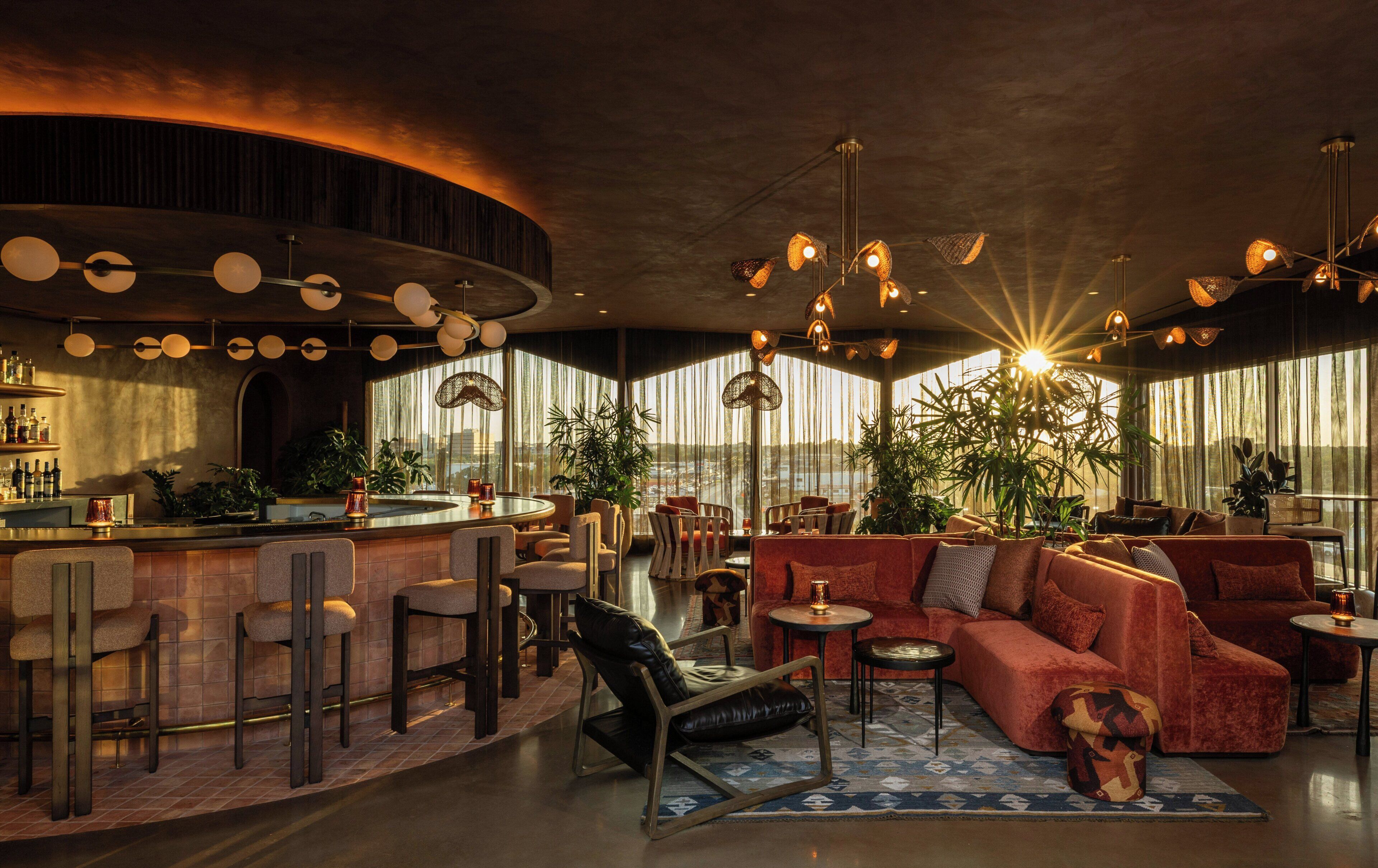 A modern interior with a bar area, seating, and large windows.
