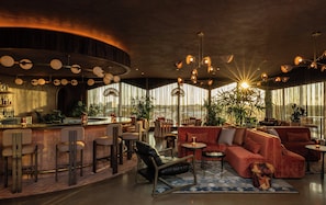 Ein modernes Interieur mit Bar, Sitzgelegenheiten und großen Fenstern.