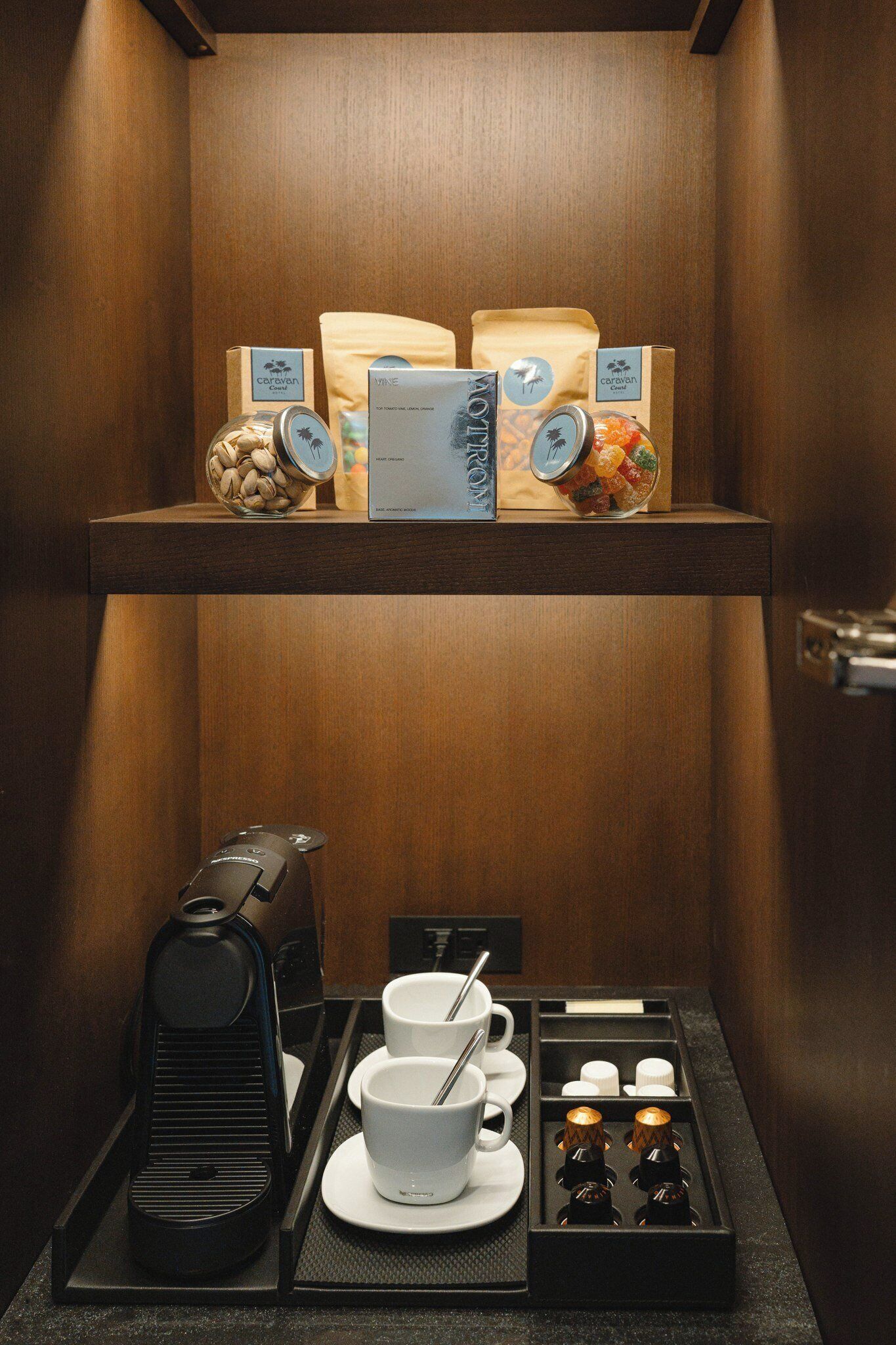 En kaffestation med kaffemaskine, kopper, sukker og fløde.
