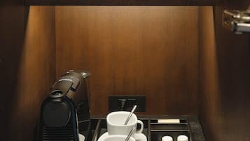Un coin café équipé d’une machine à café, de tasses, de sucre et de crème.