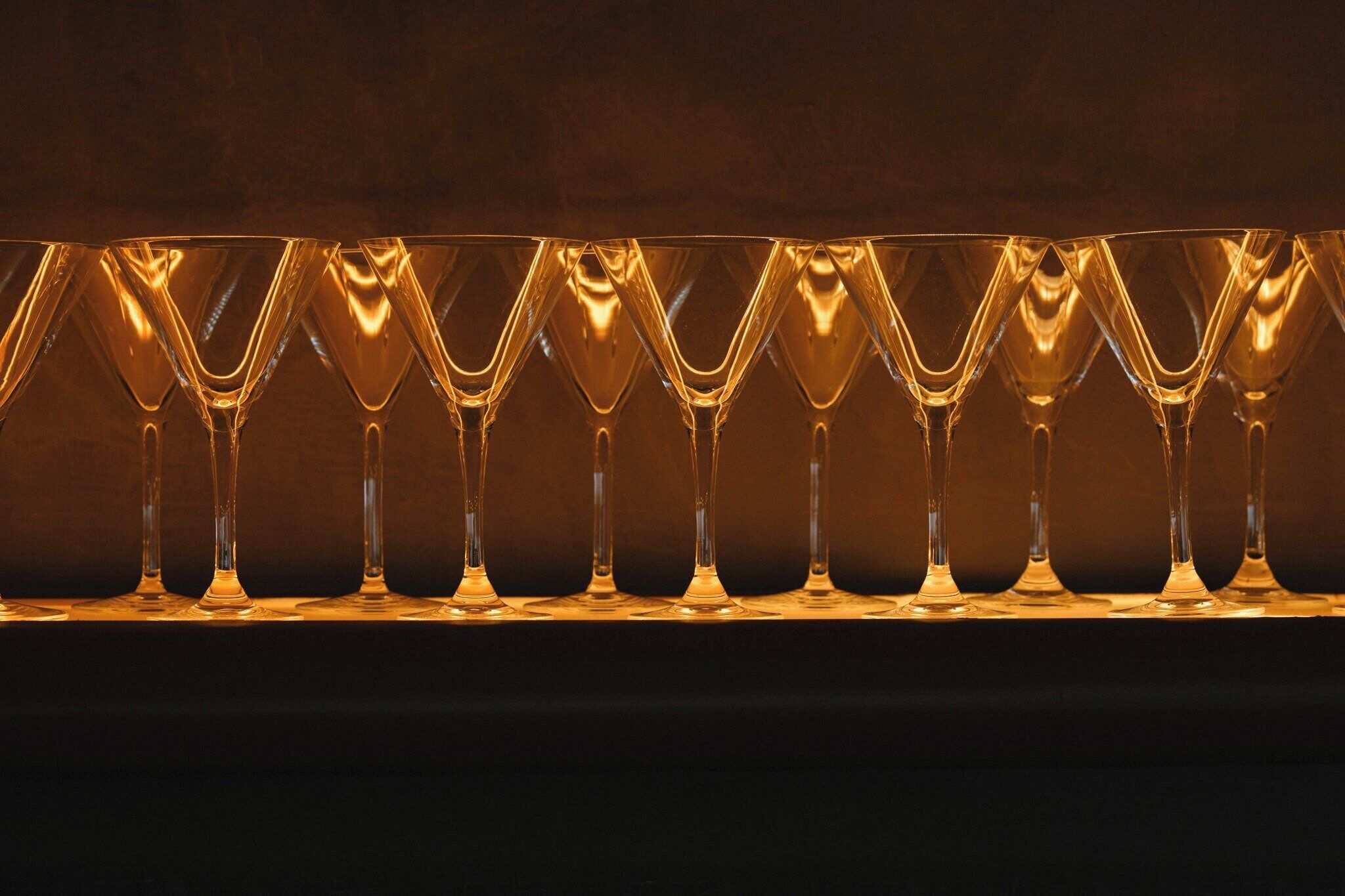 A row of empty wine glasses on a table.