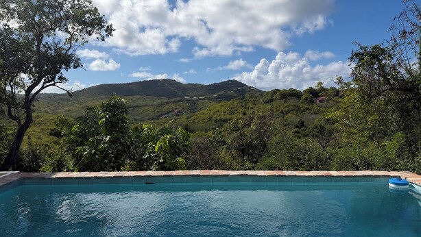 Ein Schwimmbad mit Blick auf eine gebirgige Landschaft.
