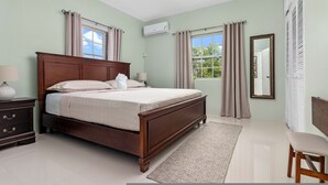 Une chambre à coucher avec un lit en bois, une table de chevet, une chaise, une fenêtre avec des rideaux et un miroir.