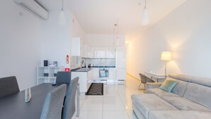 A modern apartment with a dining area, a sofa, a kitchen, and a living room. - Valley Sea Views With Furnished BBQ Balcony (St. Julian's)