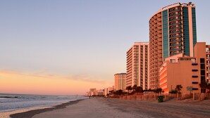 Um hotel à beira-mar com vários andares, design curvo e varandas.