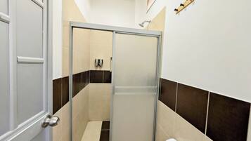 Et moderne badeværelse med en glasbrusekabine, toilet og håndklædestang.