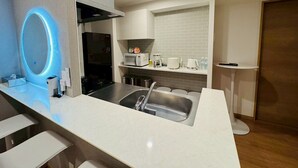 Una cocina moderna con horno empotrado, microondas y cafetera sobre la encimera.