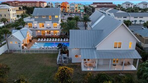 A residential area with houses, a swimming pool, and a view of the ocean. - NEW: Destin's Premier Wedding & Corporate Retreat | Outdoor Pavilion | Resort Pool (Miramar Beach)
