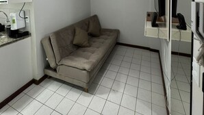 A small, modern living room with a sofa, a coffee machine, a television, and a painting on the wall. - Apartment in Brasilia, near Plano Piloto, furnished and in a great location. (Plano Piloto)