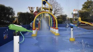 Zona de juegos acuáticos con un arcoíris y chorros de agua.