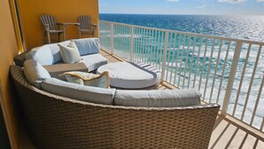 A balcony with wicker furniture, including a sofa and chairs, overlooking the ocean. - Beach Front Luxury Condo w/ Stunning Emerald Coast Views 2/ Kings (Panama City Beach)