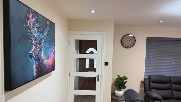 A modern living room with a large abstract painting, a black leather sofa, a wooden floor, a white door, and a wall clock. - House in Tamebridge, Walsall

Near train and bus routes to Birmingham (Walsall)