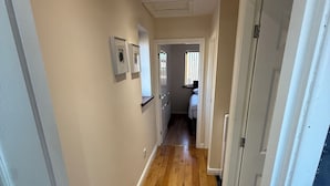 A hallway with wooden flooring, white walls, and a door leading to a bedroom. - House in Tamebridge, Walsall

Near train and bus routes to Birmingham (Walsall)