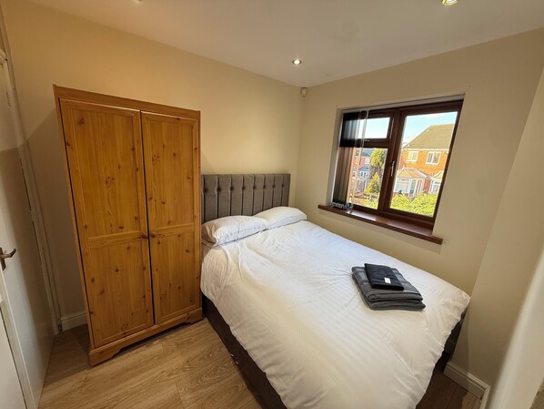 A bedroom with a bed, a wardrobe, and a window with a view of houses. - House in Tamebridge, Walsall
Near train and bus routes to Birmingham (Walsall)