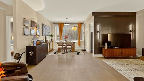 Una sala de estar moderna con comedor, chimenea y televisor.