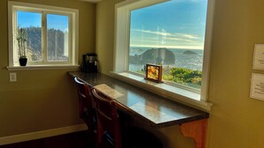 A kitchen with a large window, a coffee maker, and a framed picture on the counter. - Trinidad Coastal Retreat – Open Living, Panoramic Ocean Views & Stylish Comfort (Trinidad)