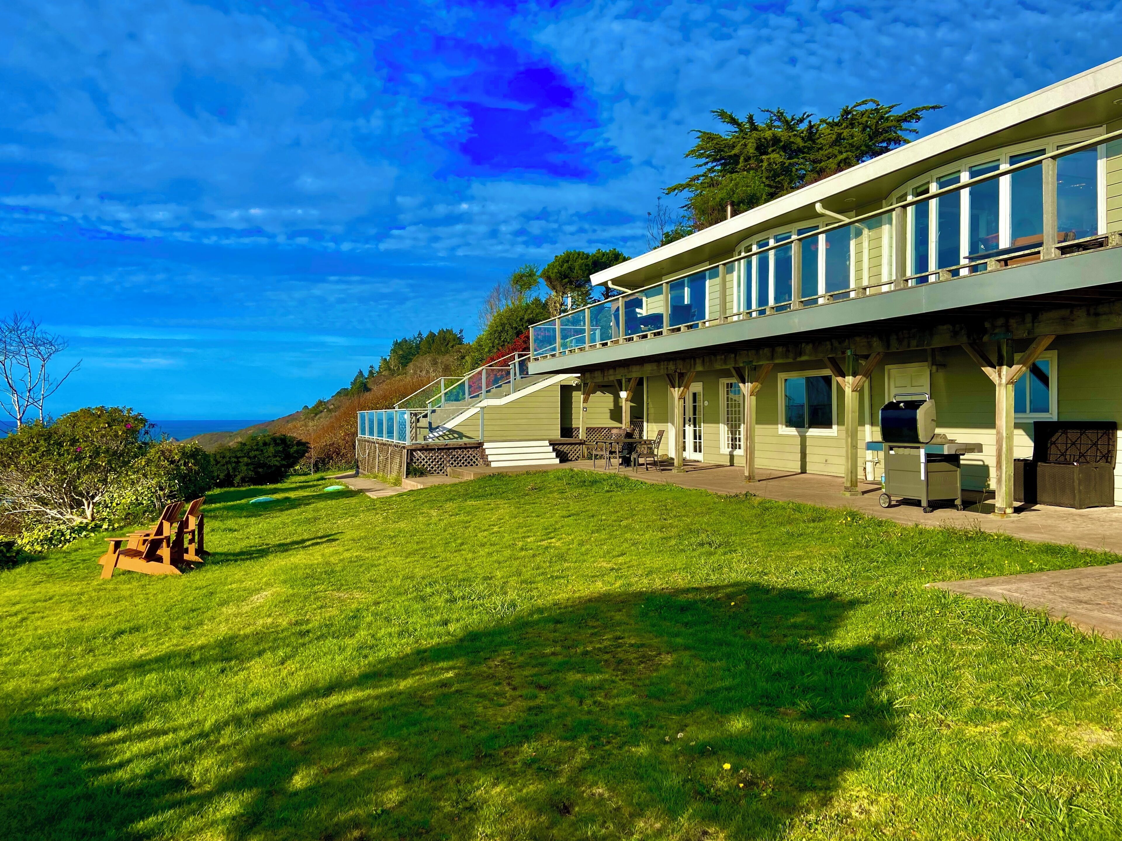 A two-story building with a balcony, outdoor seating area, and a grill.