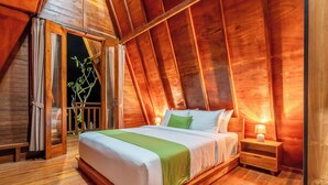 Une chambre confortable aux murs lambrissés, avec un grand lit, une table de chevet et une fenêtre avec des rideaux.