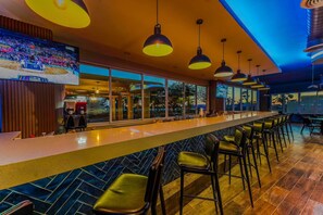A bar area with a long counter, multiple hanging pendant lights, and bar stools. - Spectacular 3 Bedroom 10 Guest D212 (Puerto Peñasco)