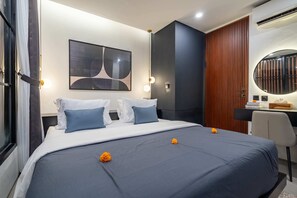 A modern hotel room with a large bed, a desk, and a large mirror. - Villa Sevu 5 (Cemagi)