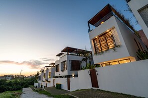 A modern residential building with a flat roof, large windows, and a paved driveway. - Villa Sevu 5 (Cemagi)