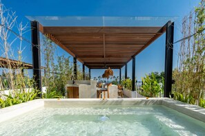 A modern outdoor pool area with a wooden pergola, seating, and lush greenery. - Villa Sevu 6 (Cemagi)