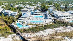 Un resort con diversi edifici, un'ampia area piscina e un pontile per l'accesso alla spiaggia.