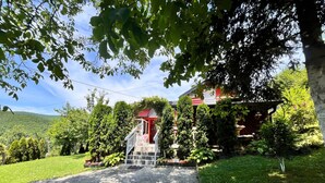 A red building with a white staircase leading to a covered entrance.