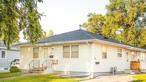 A single-story mobile home with a front porch, a small front yard, and a driveway.