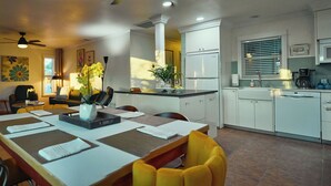 A modern kitchen with white cabinets, a built-in oven, and a coffee maker.