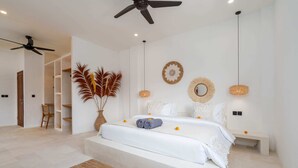 A modern bedroom with a large bed, a ceiling fan, and a bedside table with a lamp. - Villa Ombak (Cemagi)