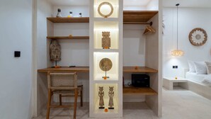 A modern room with a desk, chair, and shelves displaying decorative items. - Villa Ombak (Cemagi)
