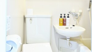 A small, clean bathroom with a toilet, sink, and mirror. There are toiletries on the sink. - Hotel Stripe Sapporo (Sapporo)