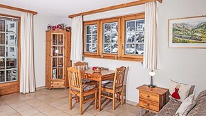 A cozy room with a wooden dining table, chairs, a cabinet, and a sofa. - Apartment Laurin by Interhome (Zermatt)