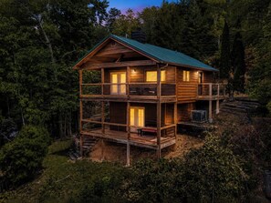 A multi-story wooden cabin with balconies, surrounded by dense forest. - Escape to Naughty by Nature in Gatlinburg: a cozy cabin for two with stunning mountain views. (Gatlinburg)