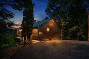 A wooden cabin with a sloped roof, a porch, and a gravel driveway. - Escape to Naughty by Nature in Gatlinburg: a cozy cabin for two with stunning mountain views. (Gatlinburg)