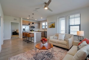 A modern kitchen with a central island, bar stools, and a dining area. - Inviting 2 BR • Near IMG Academy • Pool  (Bradenton)