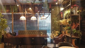 En hyggelig restaurant med spiseområde i træ, polstrede siddepladser og hængende pendellamper.