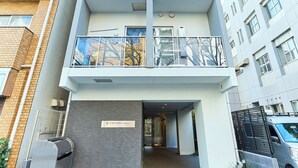 A multi-story residential building with balconies, a gated entrance, and a small parking area. - VORT Yamabukicho Residence (Tokyo)