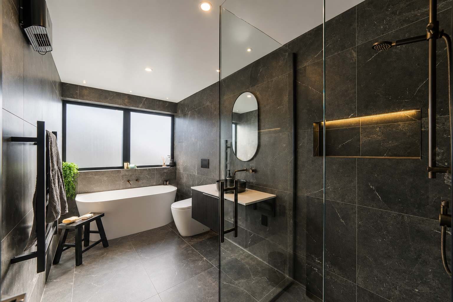A modern bathroom with a freestanding bathtub, a glass-enclosed shower, and a large mirror.