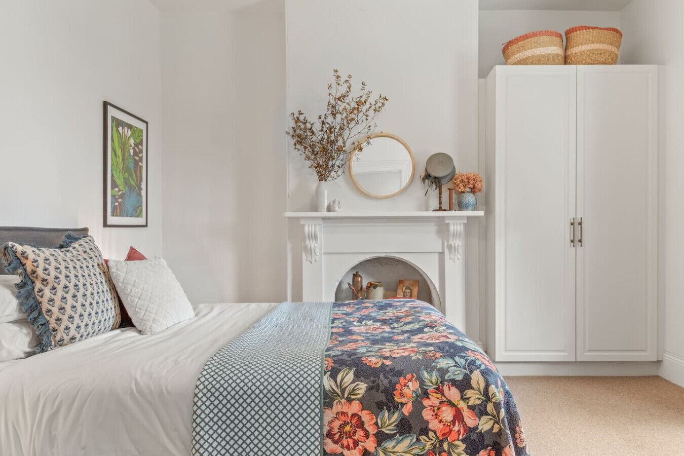 Una camera da letto con un letto, un camino, un armadio e elementi decorativi.