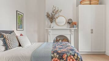 Una camera da letto con un letto, un camino, un armadio e elementi decorativi.