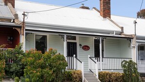 A two-story building with a white facade, a porch with white railings, and a sign that reads "Cottage on Campfire." - The Countess Central Heritage in Launceston (Launceston)