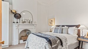A bedroom with a bed, a fireplace, a nightstand, and a mirror. - The Countess Central Heritage in Launceston (Launceston)