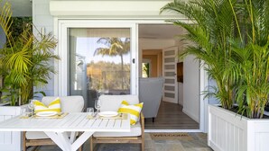 An outdoor dining area with a table, chairs, and potted plants. - Garigal Studio with Pool Access and EV charger (Forestville)