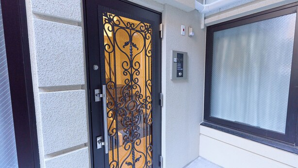 Una porta nera con un pannello di vetro decorativo e una serratura a tastierino.