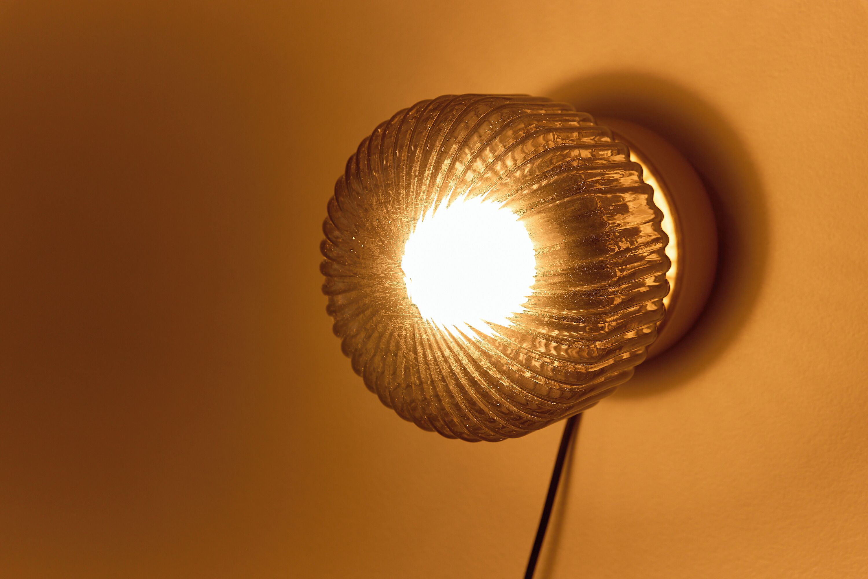 A wall-mounted light fixture with a ribbed design.