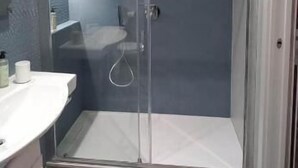 A modern bathroom with a glass shower enclosure, a white sink, and a mirror. - Classic family room for 2 to 4 people (Camerota)
