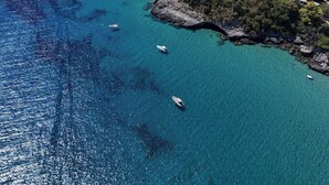An aerial view of a coastal town with clear blue waters, boats, and a mix of residential and natural landscapes. - Sea view room with private terrace (Camerota)